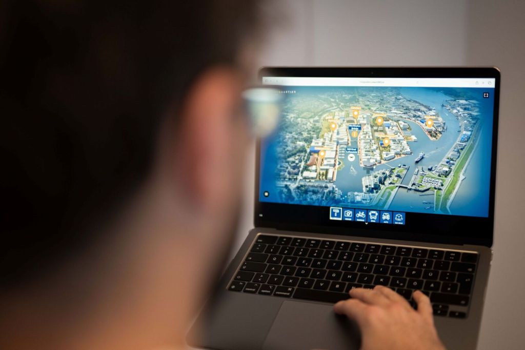 Eine Person, die an einem Laptop mit einer interaktiven Kartenansicht einer Stadt arbeitet.