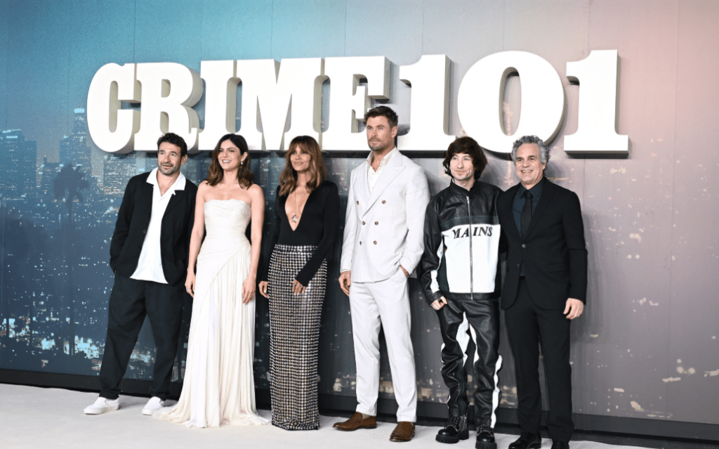 Die Besetzung von 'Crime 101' posiert gemeinsam auf dem roten Teppich vor einer filmischen Kulisse mit dem Titel des Films im Hintergrund.